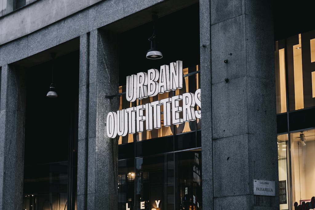 Urban Outfitters store entrance with illuminated signage in a city environment.